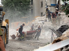 Rescuers clear the scene after a building was partially destroyed following shelling in Chasiv Yar, eastern Ukraine, on July 10, 2022. — The four-story building was hit by a Russian Hurricane missile.