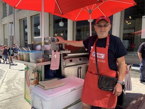 Bogdan Wozniak se para con su carrito de perritos calientes en Metcalfe Street, cerca de Sparks Street, el sábado.  Wozniak estaba en el trabajo para el Día de Canadá y se quedó sin comida a las 6 p.m.