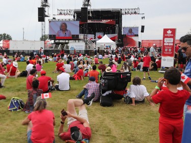 Attendees watch on the large screen as Governor-General Mary Simon speaks during Canada Day festivities on LeBreton Flats on Friday.
