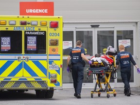 Paramedics transfer a person into a hospital in Montreal, Thursday, July 14, 2022, as the COVID-19 pandemic continues in the province causing an increase in hospitalizations.