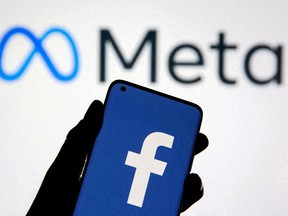 FILE PHOTO: A smartphone with Facebook's logo is seen with new rebrand logo Meta in this illustration taken October 28, 2021.