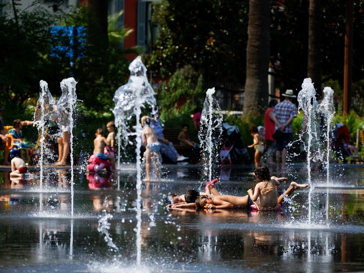  Children cool off in a fountain in Nice as a heat wave hits France, July 18, 2022. REUTERS/Eric Gaillard