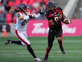 Ottawa Redblacks quarterback Caleb Evans is chased by Montreal Alouettes defensive back Marc-Antoine Dequoy (24) during the first half.