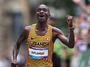 Uganda's Victor Kiplangat celebrates as he crosses the line to win gold in the men's marathon.