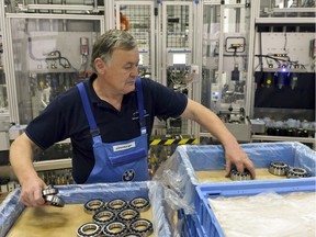 At Bayerische Motoren Werke AG (BMW), a older worker unpacks bearings in this file photo. Part of the BMW assembly line was optimized for older workers at the company's plant in Dingolfing, Germany. In 2007, the luxury automaker set up an experimental assembly line with older employees in Dingolfing, featuring hoists to spare aging backs, adjustable-height work benches, and wooden floors instead of rubber to help hips swivel during repetitive tasks.