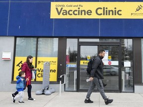 People walk past a vaccine clinic during the COVID-19 pandemic in Mississauga, Ont., on Wednesday, April 13, 2022.