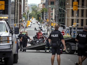 Los policías observan como un operador de grúa retira una motocicleta estacionada ilegalmente en el 