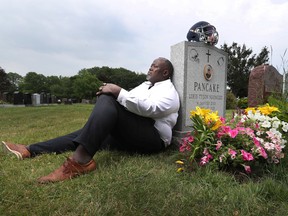 Jooris Ndongozi, the father of Tyson Ndongozi, shot dead a year ago, visits his son's grave in Ottawa on Tuesday.