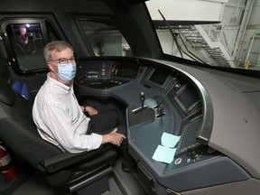 Mayor Jim Watson checks out the driver's view in one of the new fleet of light-rail trains unveiled at the maintenance and storage facility for O-Train South Extension on Friday.