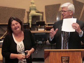 Departing city councillor Doug Thompson gives Sun reporter Sue Sherring a signed autographed photo of the band Kiss during his speech Wednesday.