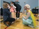 File photo: 27 January 2022. Nora Burroughs (6) and her mother Angela were happy to see Guylaine Chartier, dressed as Elsa, as she was vaccinated on Thursday.  Ottawa Public Health staff dressed as superheroes to help children as they put a needle in them.   