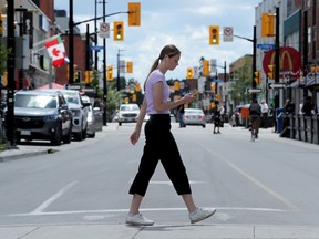 Pedestrians and cyclists around crosswalk on Elgin Street, near Lisgar in downtown Ottawa.