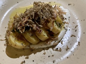 Sliced ​​potatoes in salt and vinegar with ricotta, truffle shavings and a white anchovy gremolata.