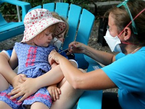 Josephine Jackson Villeneuve, 2, gets held by her big brother Sam, 9 — who’s already had his COVID-19 vaccine — while she gets hers from Dr. Nili Kaplan-Myrth on Thursday.