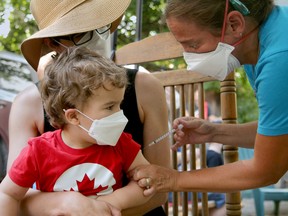 Dr. Nili Kaplan-Mryth administers a pediatric COVID-19 vaccine to 2-year-old Paolo Cargnello with his mother, Claire Ezzeddin.