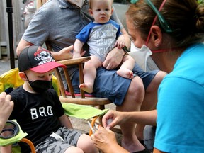 Three-year-old Bowen prepares for his shot while his little brother, Anton, eight months, looks on. Their mom, Jessica Matwick was a nurse helping out at the event. 
Dr. Nili Kaplan-Myrth held a 'Jabapalooza' mass COVID vaccination event in the parking lot behind her doctor's office in the Glebe Thursday.
Vaccines are now available for kids six months old to five years old and there were no shortage of parents and kids at the event, which had live music, nurses with wings and happy stickers and book giveaways.
Julie Oliver/Postmedia