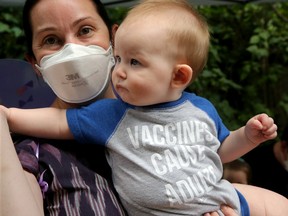 FILE: Nurse Jessica Matwick holds her baby, Anton, eight months, after his shot. His onesie reads 'vaccines cause adults.'