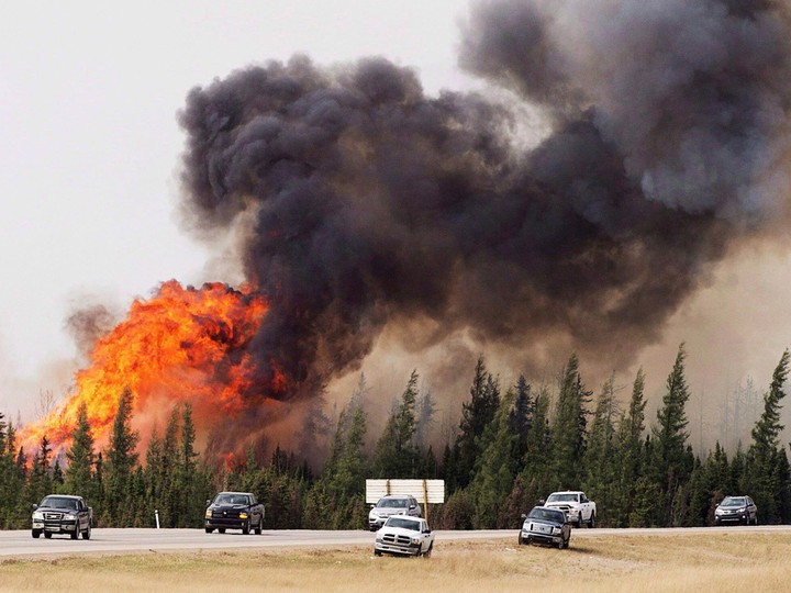  A convoy of evacuees from Fort McMurray, Alta., drive past wildfires still burning out of control on Saturday, May 7, 2016. The increasing frequency of wildfires in Canada’s boreal forest may be permanently changing one of the largest intact ecosystems left on Earth, research suggests.THE CANADIAN PRESS/Ryan Remiorz