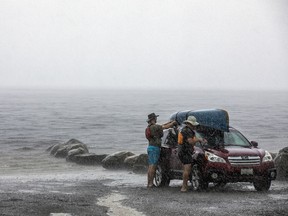 The scorching hot weather broke as a storm rolled through Shirleys Bay along the Ottawa River where paddlers were enjoying the sunshine and made their way in to shore as the storm hit, Sunday, August, 7, 2022. Paddlers load up their canoe in the pouring rain Sunday afternoon.
