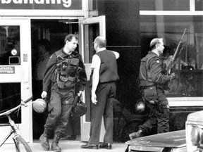 Police officers leave the Henry F. Hall Building at Concordia University on Aug. 24, 1992, after professor Valery Fabrikant shot and killed four colleagues.