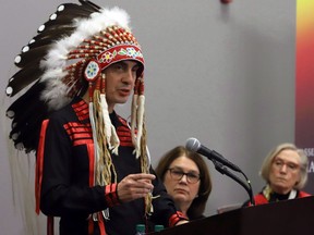 Grand Chief Arlen Dumas, left, speaks during a signing ceremony to improve child and family services in Manitoba First Nations communities, as Indigenous Services Minister Jane Philpot (centre), Northern Affairs Minister Carolyn Bennet look on in Ottawa on Dec. 7, 2017.