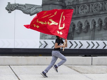 A boy runs with a flag on Parliament Hill prior to a commemoration of the martyrdom of Imam Hussain, grandson of the Islamic prophet Mohammad, on Monday, Aug. 8, 2022.