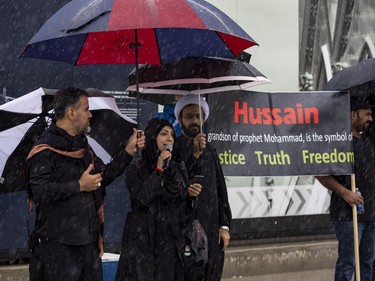 Berak Hussain, a Muslim counsellor at Carleton University and community leader, speaks in a heavy downpour on Parliament Hill during a commemoration of the martyrdom of Imam Hussain, grandson of the Islamic prophet Mohammad, on Monday, Aug. 8, 2022.