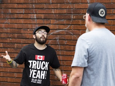 A supporter of The United People of Canada (TUPOC), left, argues with a neighbourhood resident outside of the former St. Brigid's church in Lowertown.