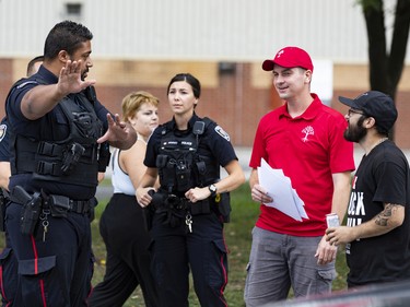 The United People of Canada (TUPOC) director William Komer (red shirt) speaks to Ottawa Police outside of the former St. Brigid's church in Lowertown.