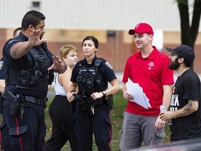 Der Direktor der United People of Canada (TUPOC), William Komer (rotes Hemd), spricht mit der Polizei von Ottawa vor der ehemaligen St. Brigid's Church in Lowertown.