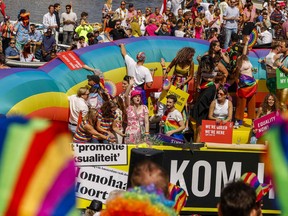 Participants attend the Canal Parade on a boat along the Amstel river in Amsterdam, on August 6, 2022.