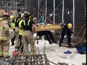 Rescuers lift a person who had been struck by a beam out of a 13-metre pit at a Tunney's Pasture construction site.