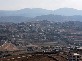A picture shows a view of the southern Lebanese border village of Yaroun, on August 13, 2022, with a view of areas in northern Israel in the background. - On August 12, 2022, Hadi Matar, 24, stabbed British author Salman Rushdie at a literary event in New York state. State police said