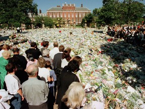 FILE PHOTO: Mourners surround a carpet of flowers outside Kensington Palace, where mourners have been gathering all week to lay flowers and pay their last respects to Diana, Princess of Wales, in London, Britain September 4, 1997.