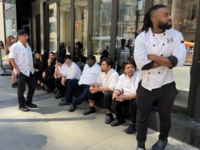 Kitchen staff wait outside a restaurant during an electricity power outage in Toronto, Ontario, Canada August 11, 2022.