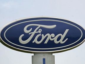 FILE - A Ford logo is seen on signage at Country Ford in Graham, N.C., Tuesday, July 27, 2021. Ford Motor Co. is cutting about 3,000 white-collar workers as it moves reduce costs and make the transition from internal combustion to electric vehicles, leaders of the Dearborn, Mich., automaker announced Monday, Aug. 22, 2022, in a companywide email.