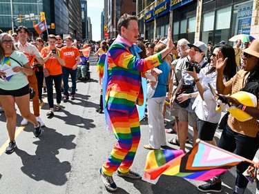 Ontario NDP Member of Provincial Parliament for Ottawa Centre Joel Harden high fives participants during the 2022 Capital Pride Parade in Ottawa on Sunday, Aug. 28, 2022.