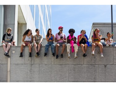 People sit on a ledge as the 2022 Capital Pride Parade makes its way through the downtown core of Ottawa on Sunday, Aug. 28, 2022.
