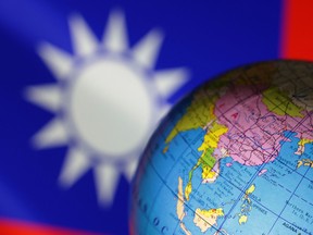 Files: A globe is seen in front of Chinese and Taiwanese flags in this illustration, August 6, 2022.
