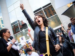 Maryam Fatahi stood in front of the crowd on a bench and cut off curly locks of hair to show her support for Iranian women.  Fatahi shouted with the crowd.