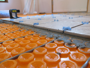 The gray electric heating cables snap into the orange decoupling membrane that sits under ceramic tile.  This is the ideal system to add warm floors to small spaces in your home.