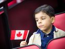 Then-six-year-old Omar Alokel holds his flag during a citizenship ceremony in Ottawa on Jan. 18, 2020. 