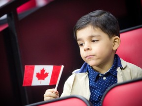 Omar Alokel, alors âgé de six ans, tient son drapeau lors d'une cérémonie de citoyenneté à Ottawa le 18 janvier 2020.