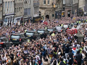 Crowds watch a cortege carrying the coffin of the late Queen Elizabeth II in Edinburgh.