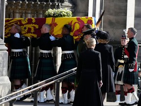Royal guards carry Queen Elizabeth's coffin into St Giles Cathedral after its journey from Palace of Holyroodhouse on September 12, 2022 in Edinburgh, Scotland.. It lies in rest for 24 hours before being transferred by air to London.
