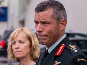 Maj.-Gen. Dany Fortin makes a statement to the media outside Gatineau police headquarters on Aug. 18, 2021, as his wife, Madeleine Collin, listens on.