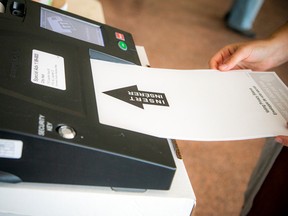 Von einem Sichtschutz abgedeckt, wird am Samstag ein Stimmzettel in einem Abstimmungsvorgang im Rathaus von Ottawa eingereicht.