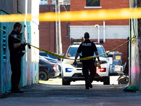 Ottawa police investigate at the scene of the stabbing of a woman near Bank Street and McLaren Street on Friday.