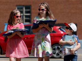 Bronwyn, Ainsley and Keaton walk with their new virtual online school supplies in Ottawa earlier this week.