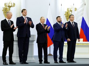 (L-R) The Moscow-appointed heads of Kherson region Vladimir Saldo and Zaporizhzhia region Yevgeny Balitsky, Russian President Vladimir Putin, Donetsk separatist leader Denis Pushilin and Lugansk separatist leader Leonid Pasechnik applaud after signing treaties formally annexing four regions of Ukraine Russian troops occupy, at the Kremlin in Moscow on September 30, 2022.